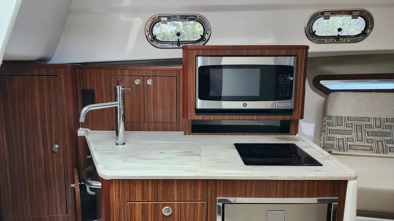 Slide: The Image of 2023 Pursuit OS 325 Offshore yacht kitchen with microwave, sink, and stove. - 27