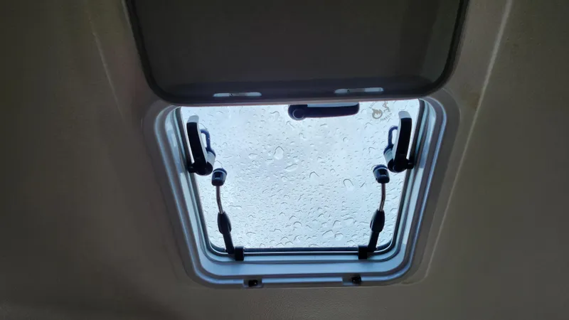 Slide: The Image of Open hatch with raindrops on glass, Pursuit OS 325 Offshore 2023 boat. - 31