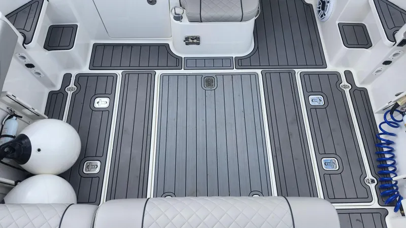 Slide: The Image of 2023 Pursuit OS 325 Offshore boat deck with gray non-slip flooring and storage compartments. - 39