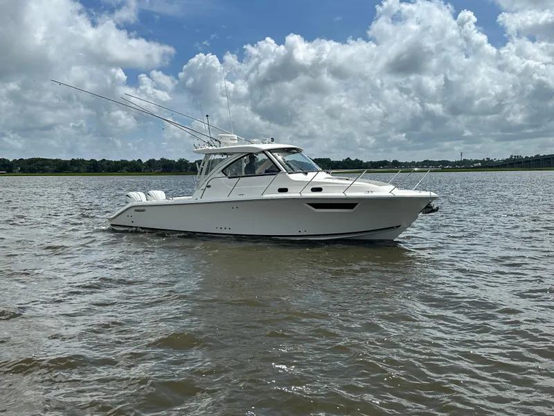 Slide: The Image of 2023 Pursuit OS 325 Offshore boat on calm water under a cloudy sky. - 4