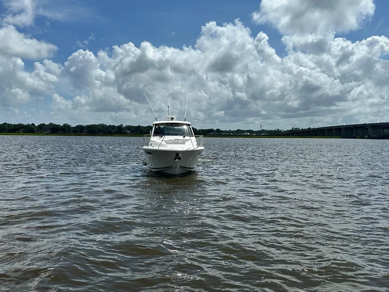 Slide: The Image of 2023 Pursuit OS 325 Offshore boat on calm water under a cloudy sky. - 7