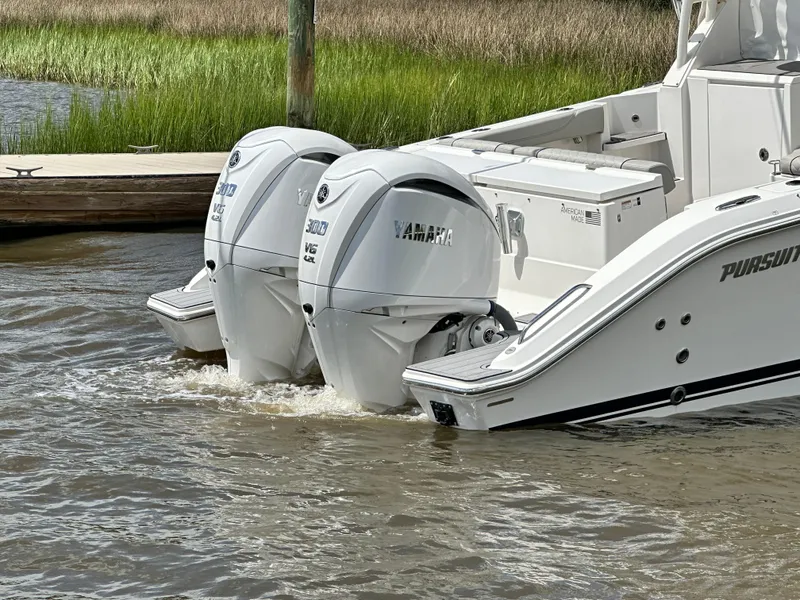 Slide: The Image of 2023 Pursuit OS 325 Offshore boat with twin Yamaha outboard engines in water. - 8