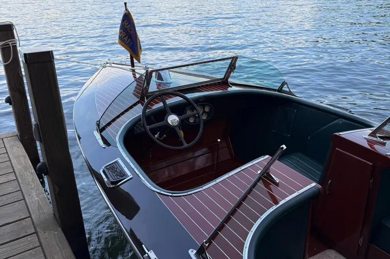 Slide: The Image of 1997 Hacker-Craft 26' Runabout docked on calm water, showcasing classic wooden design. - 10