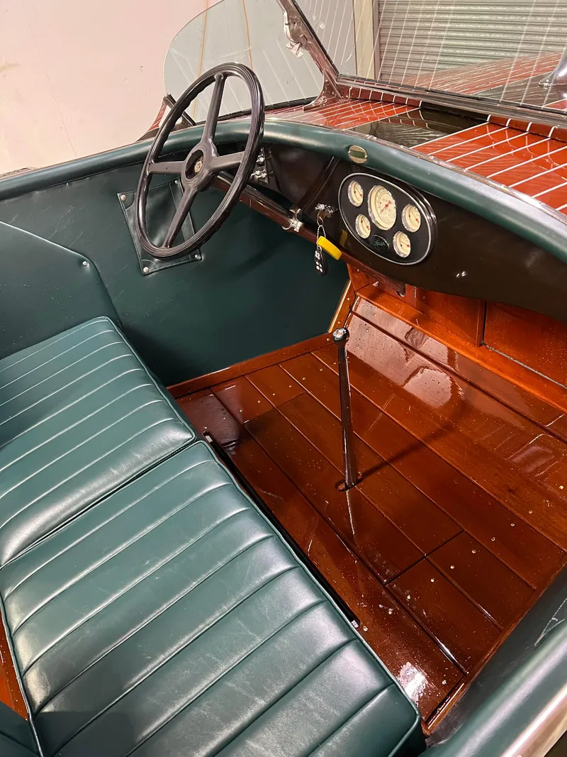 Slide: The Image of Interior of a 1997 Hacker-Craft 26' Runabout with green seats and wooden dashboard. - 12