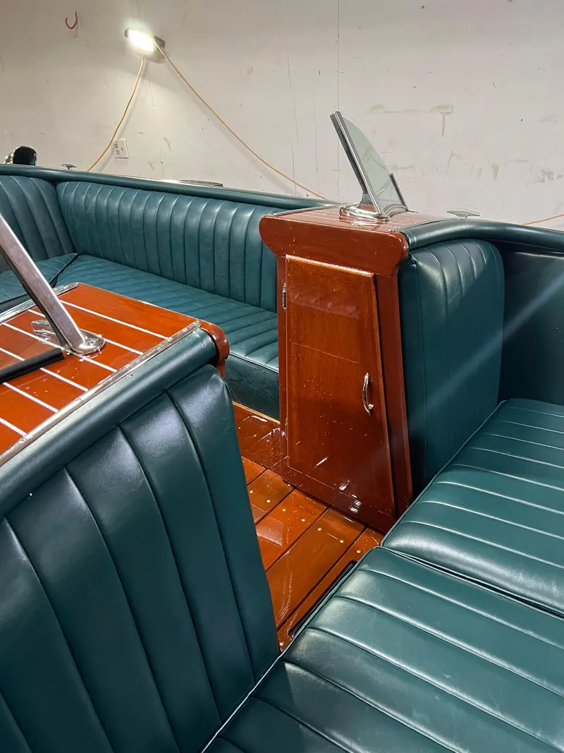 Slide: The Image of Interior of a 1997 Hacker-Craft 26' Runabout with teal leather seating and wooden accents. - 15