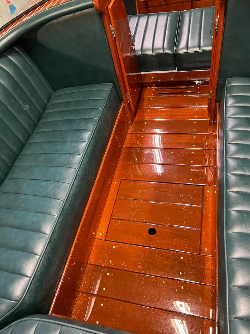 Slide: The Image of Interior of a 1997 Hacker-Craft 26' Runabout with polished wood and green leather seats. - 16