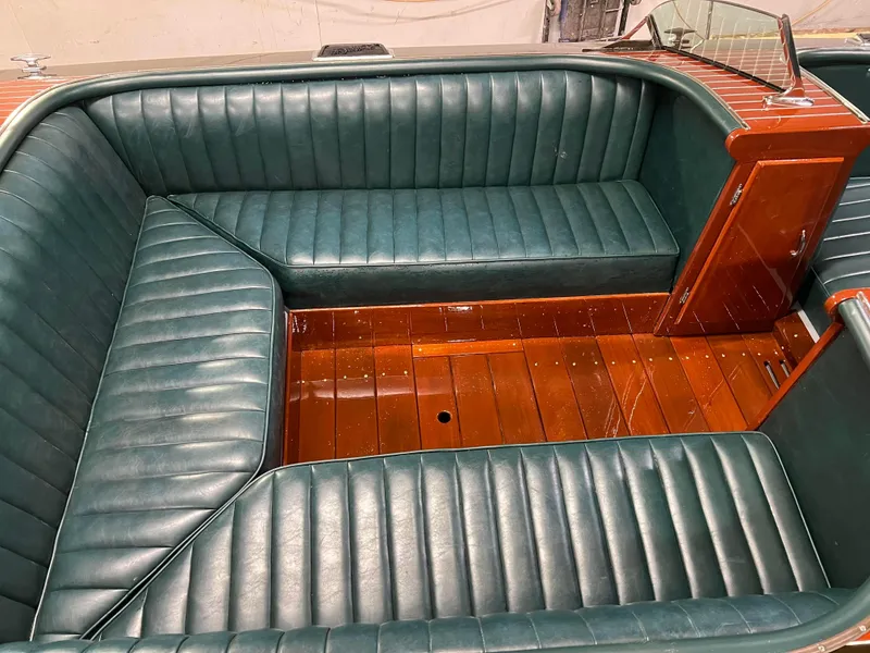 Slide: The Image of Interior of a 1997 Hacker-Craft 26' Runabout with green leather seating and wooden flooring. - 17