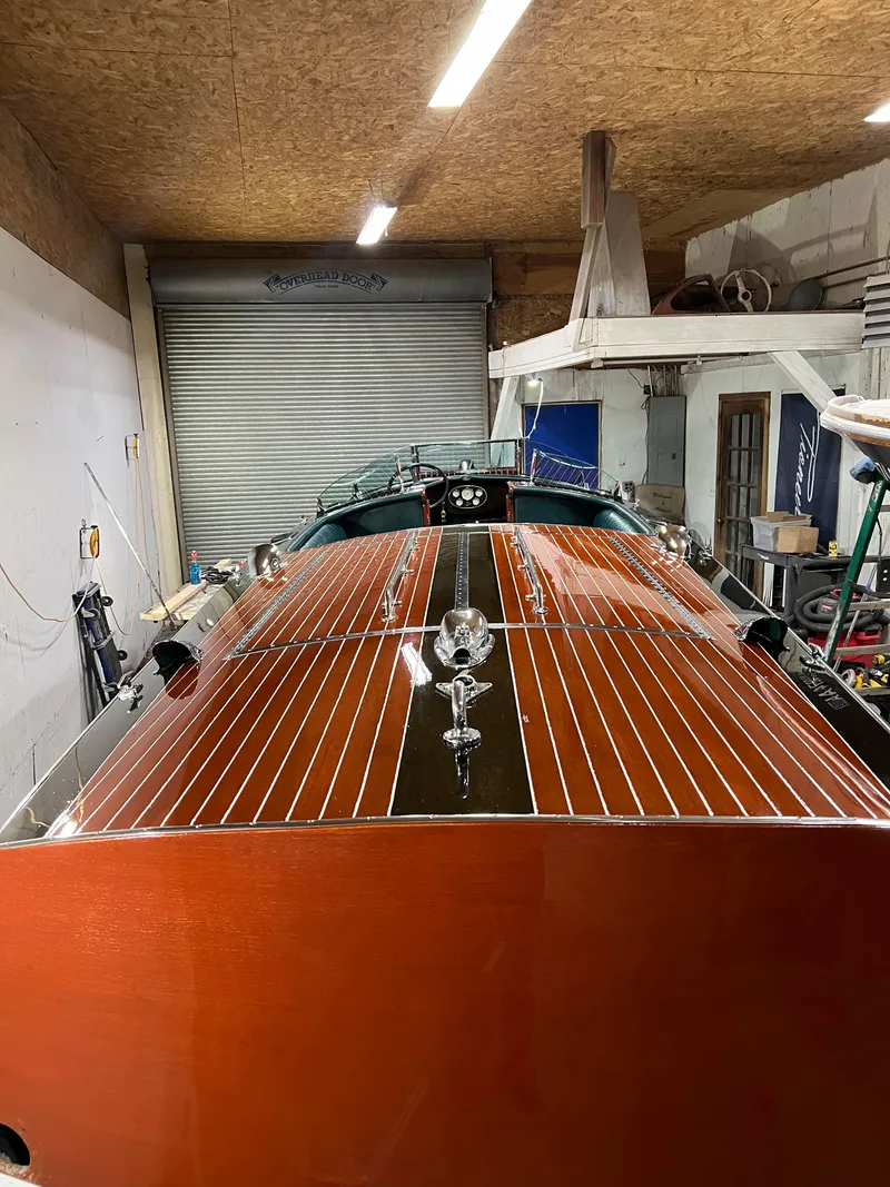 Slide: The Image of 1997 Hacker-Craft 26' Runabout with polished wood finish in a garage setting. - 18