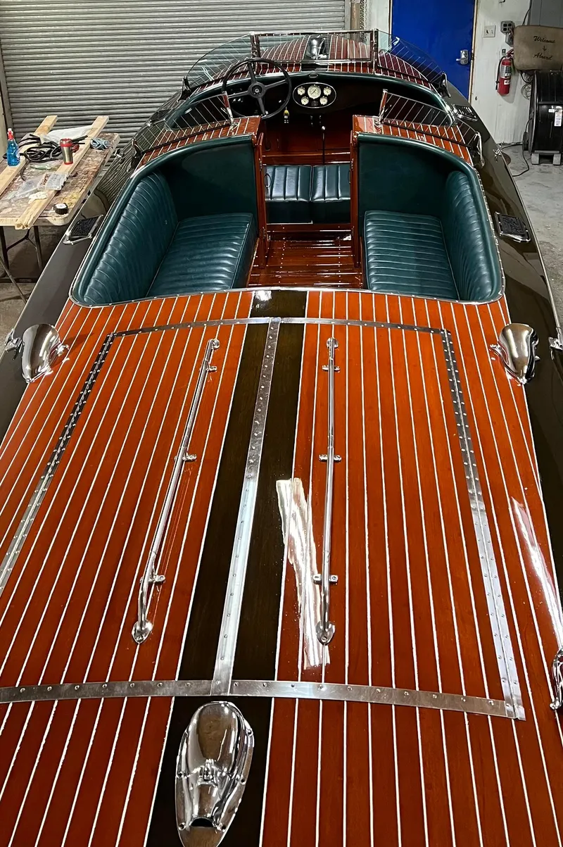 Slide: The Image of 1997 Hacker-Craft 26' Runabout with polished wood finish and green leather seating. - 21