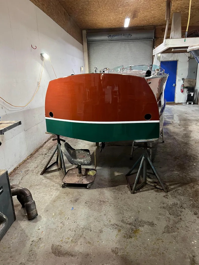 Slide: The Image of 1997 Hacker-Craft 26' Runabout in workshop, showcasing polished wooden hull. - 26