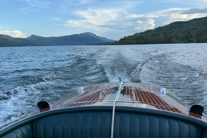 Slide: The Image of 1997 Hacker-Craft 26' Runabout cruising on a scenic lake with mountains in the background. - 27