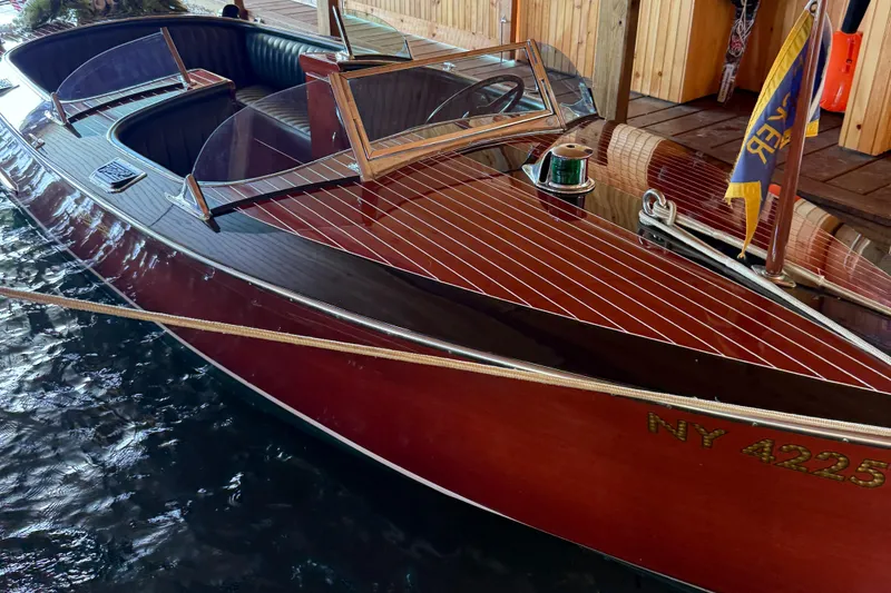 Slide: The Image of 1997 Hacker-Craft 26' Runabout boat docked, showcasing polished wood finish and classic design. - 4