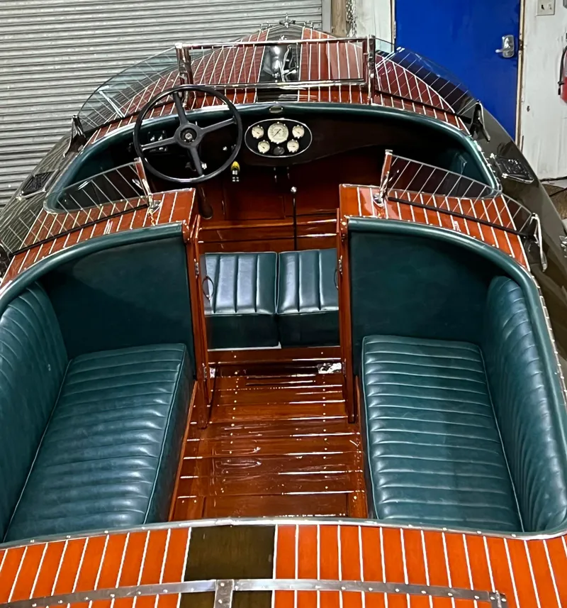 Slide: The Image of 1997 Hacker-Craft 26' Runabout with polished wood finish and green leather seating. - 9