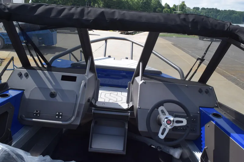Slide: The Image of Interior view of 2026 Stabicraft 2050 Treker Profish boat, featuring steering console and seating. - 11
