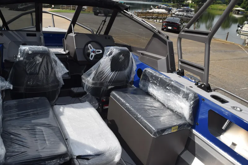 Slide: The Image of 2026 Stabicraft 2050 Treker Profish boat interior with plastic-covered seats at a marina. - 27