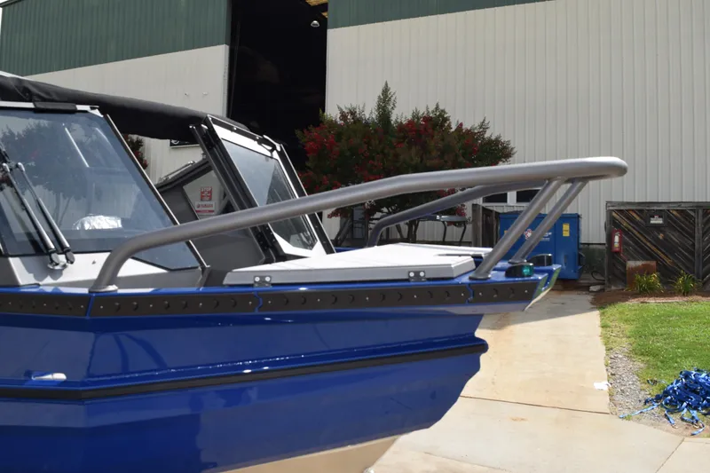 Slide: The Image of 2026 Stabicraft 2050 Treker Profish boat, blue exterior, docked near a warehouse. - 3