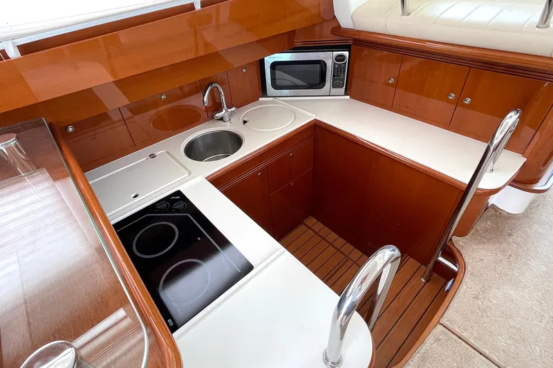 Slide: The Image of Luxurious kitchen in 2007 Jeanneau Prestige 46 yacht with modern appliances and wood finish. - 12