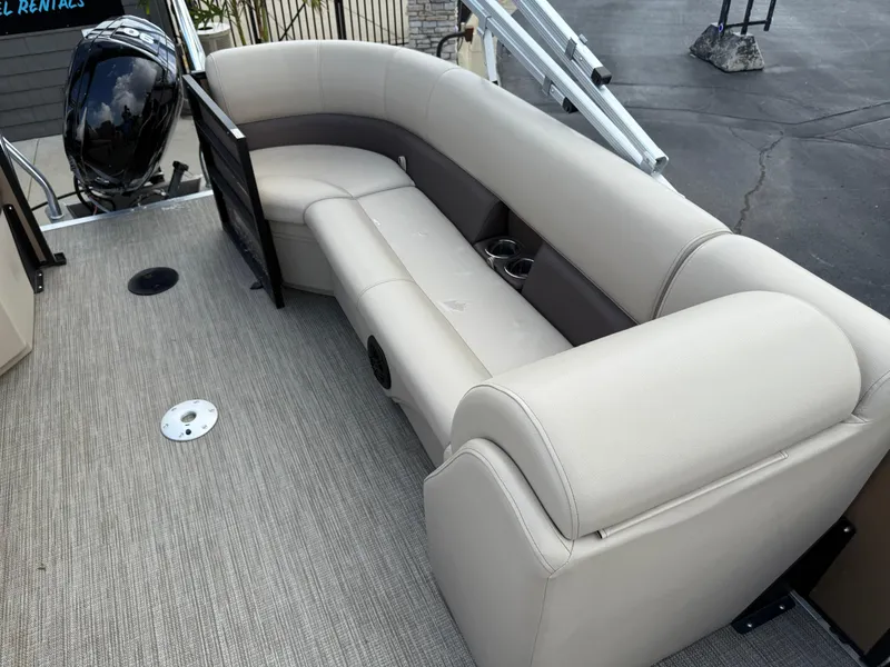 Slide: The Image of 2023 Bentley Pontoons LE 200 interior with beige seating and outboard motor. - 16