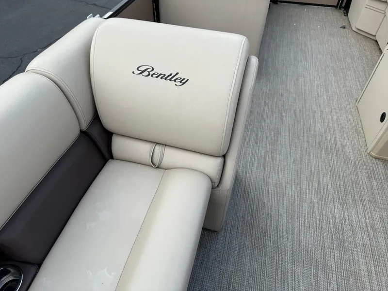 Slide: The Image of 2023 Bentley Pontoons LE 200 interior with beige seating and carpeted flooring. - 17