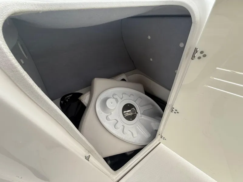 Slide: The Image of Storage compartment in a 2011 Yamaha SX240 HO boat, featuring a life jacket and equipment. - 11