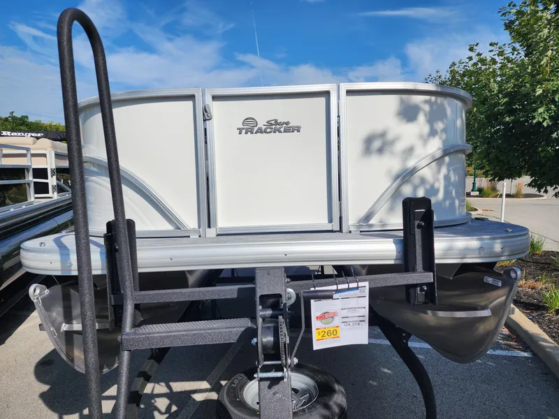 Slide: The Image of 2026 Sun Tracker Party Barge 16 pontoon boat on trailer, displayed outdoors. - 2