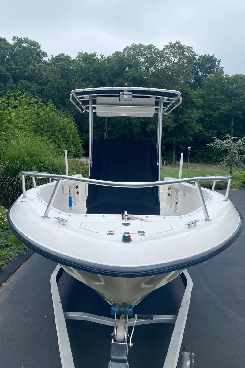 Slide: The Image of 2001 Mako 192 Center Console boat on trailer, surrounded by lush greenery. - 2