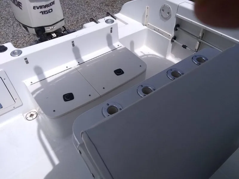 Slide: The Image of 2001 Mako 192 Center Console boat interior with Evinrude 150 engine, rod holders, and storage compartments. - 6