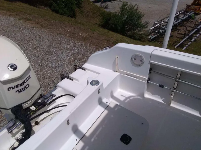 Slide: The Image of 2001 Mako 192 Center Console boat with Evinrude 150 outboard motor, docked on gravel. - 8