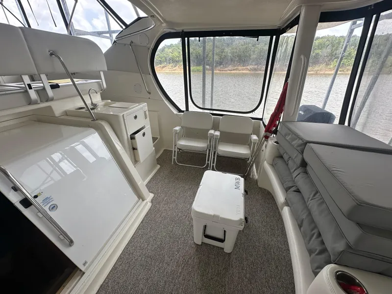 Slide: The Image of 2008 Silverton 35 Motor Yacht interior with seating, cooler, and river view. - 13