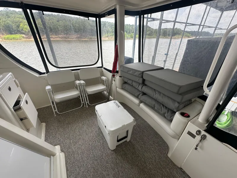 Slide: The Image of 2008 Silverton 35 Motor Yacht interior with seating, cushions, and cooler, overlooking a serene water view. - 14