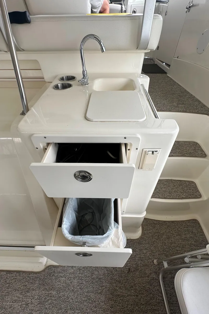 Slide: The Image of 2008 Silverton 35 Motor Yacht interior with sink, storage drawers, and trash bin. - 16