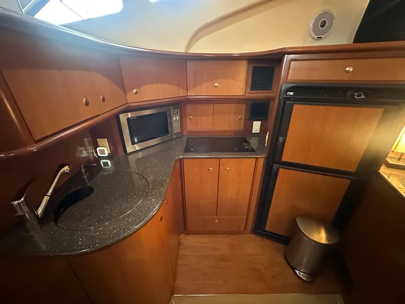 Slide: The Image of 2008 Silverton 35 Motor Yacht kitchen with wood cabinets, microwave, and refrigerator. - 27