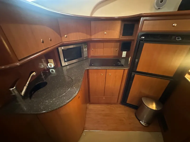 Slide: The Image of 2008 Silverton 35 Motor Yacht kitchen with wood cabinets, microwave, and refrigerator. - 28