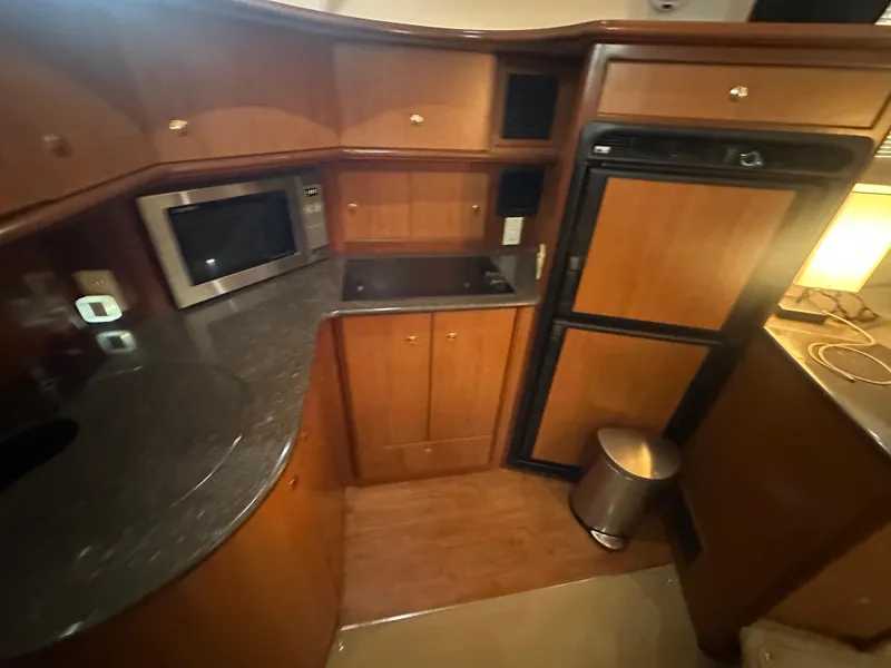 Slide: The Image of 2008 Silverton 35 Motor Yacht kitchen with microwave, fridge, and wooden cabinetry. - 30