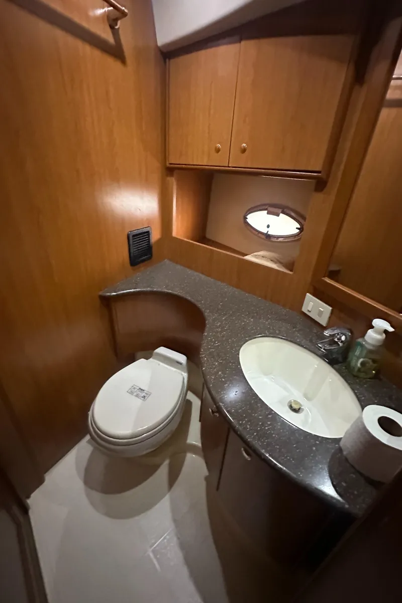 Slide: The Image of 2008 Silverton 35 Motor Yacht bathroom with wood cabinetry, sink, and toilet. - 35