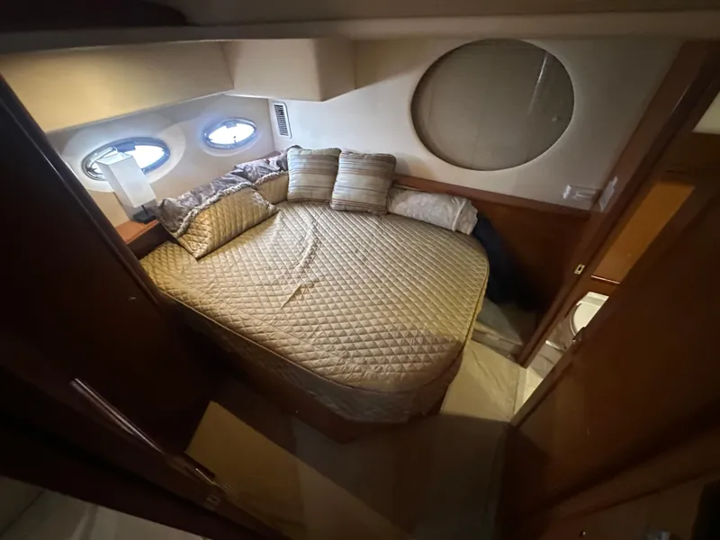 Slide: The Image of 2008 Silverton 35 Motor Yacht bedroom with cozy bed and porthole windows. - 40