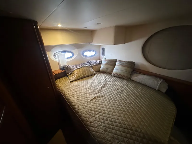 Slide: The Image of 2008 Silverton 35 Motor Yacht bedroom with cozy bed, pillows, and porthole windows. - 42