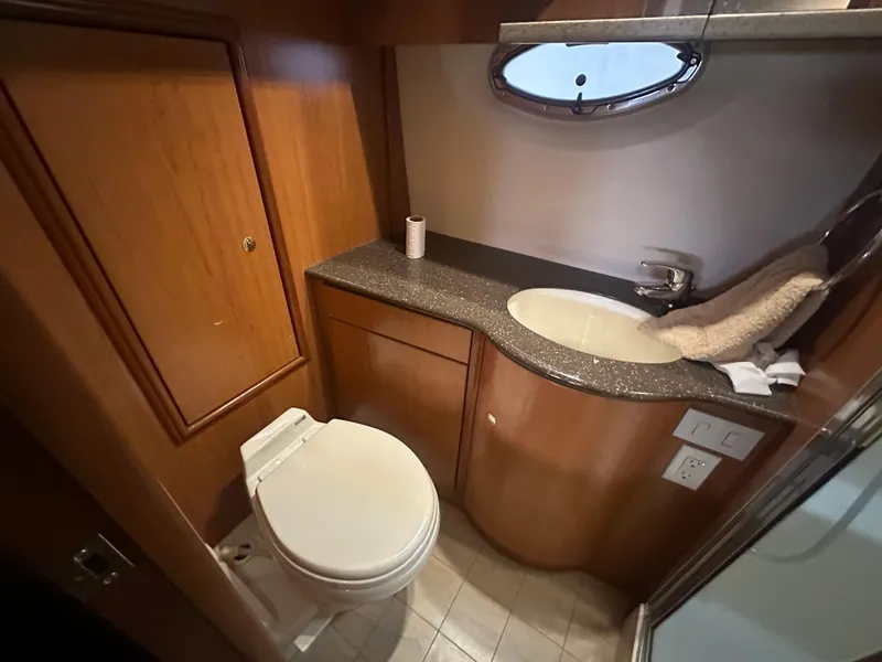 Slide: The Image of 2008 Silverton 35 Motor Yacht bathroom with toilet, sink, and wooden cabinetry. - 46