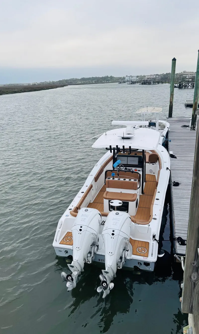 Slide: The Image of 2024 Sea Hunt Ultra 305 SE boat docked, featuring dual engines and spacious deck. - 14