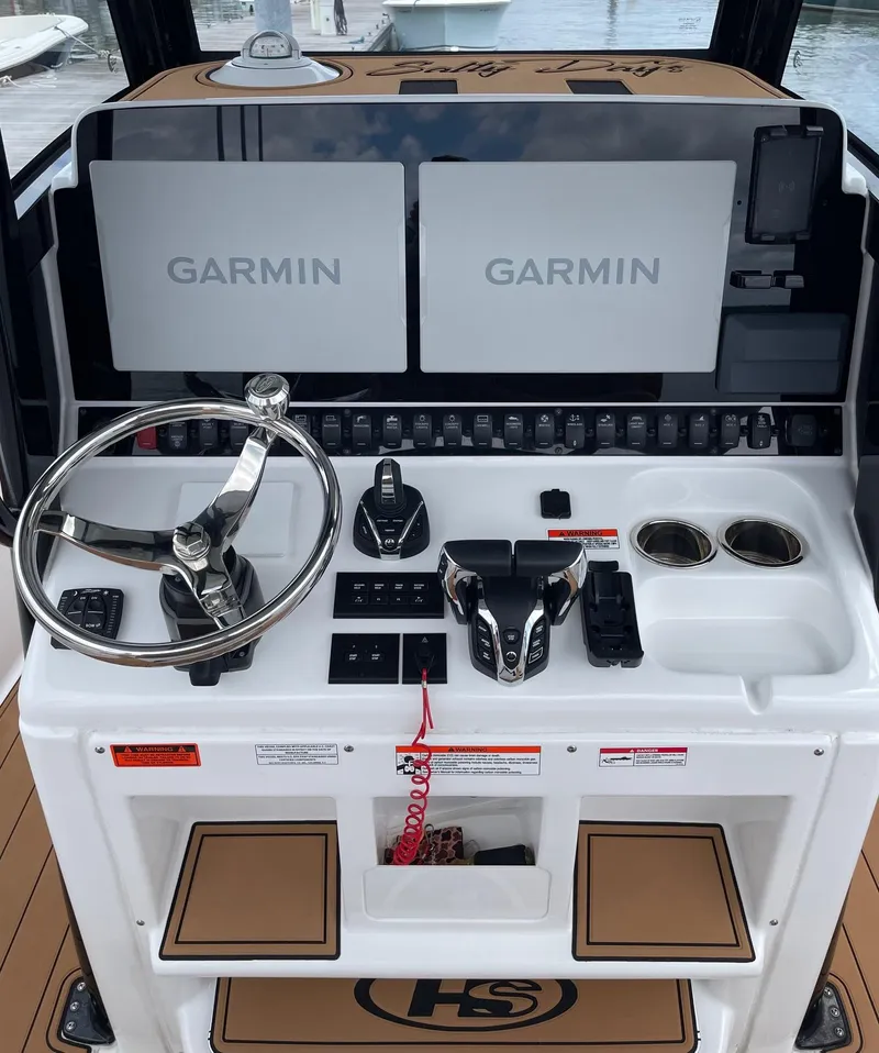 Slide: The Image of 2024 Sea Hunt Ultra 305 SE boat dashboard with Garmin displays and steering wheel. - 16