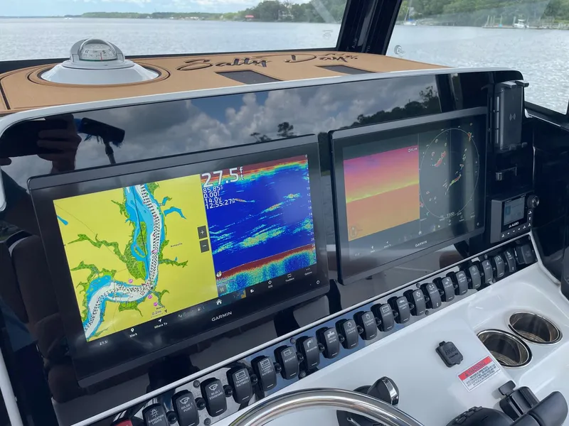 Slide: The Image of 2024 Sea Hunt Ultra 305 SE dashboard with dual Garmin displays and navigation controls. - 20