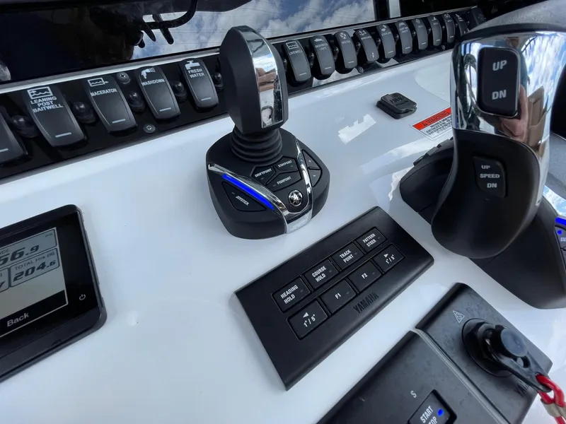 Slide: The Image of Control panel of 2024 Sea Hunt Ultra 305 SE boat with joystick and switches. - 21