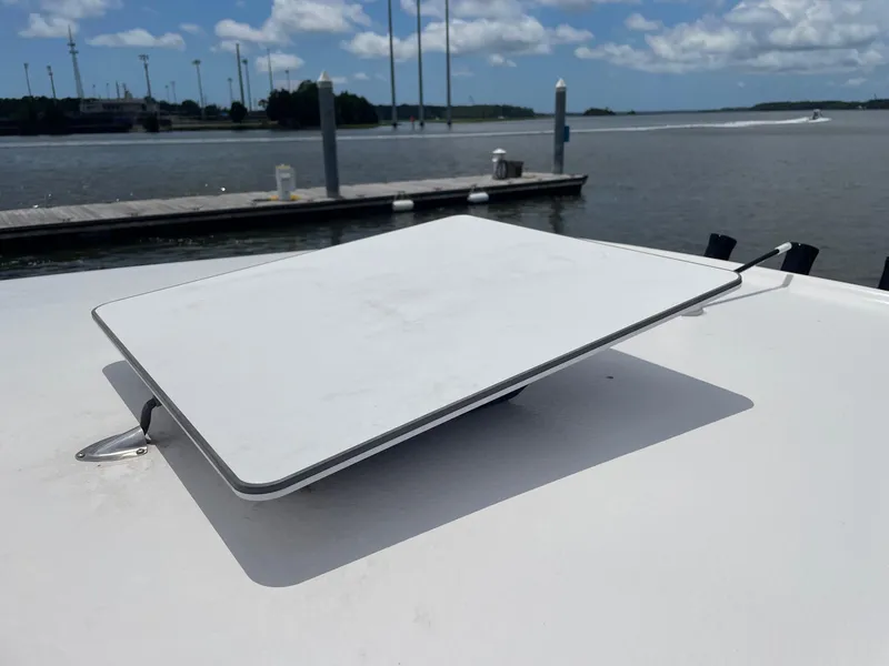 Slide: The Image of Satellite dish on 2024 Sea Hunt Ultra 305 SE boat, docked by the water. - 27