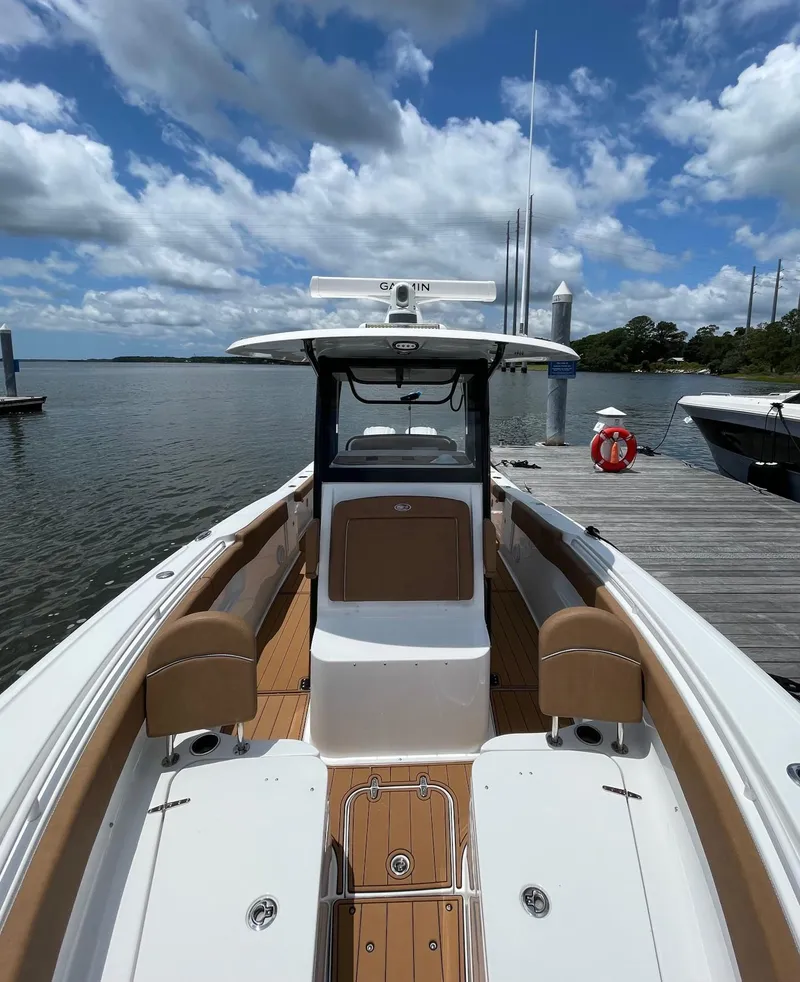 Slide: The Image of 2024 Sea Hunt Ultra 305 SE boat docked under a partly cloudy sky. - 29