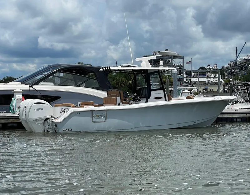 Slide: The Image of 2024 Sea Hunt Ultra 305 SE boat docked, featuring Yamaha engines, under a cloudy sky. - 3