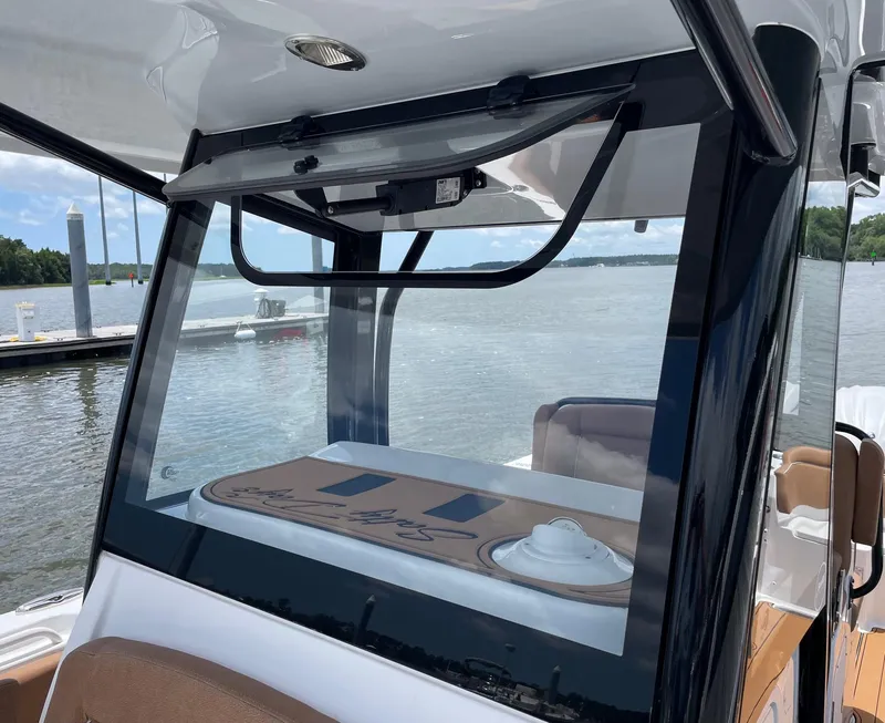 Slide: The Image of 2024 Sea Hunt Ultra 305 SE boat interior with open window, dockside view. - 30