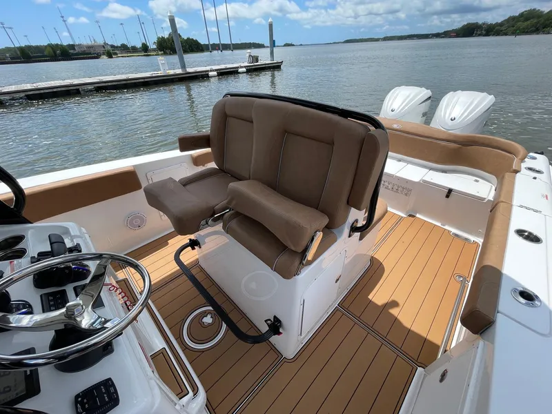 Slide: The Image of 2024 Sea Hunt Ultra 305 SE boat interior with brown seating and dual engines. - 32