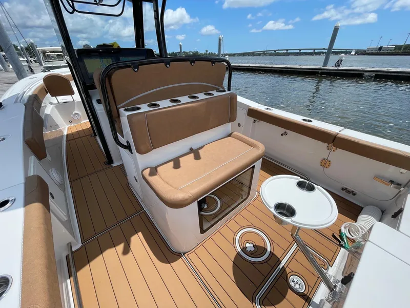 Slide: The Image of 2024 Sea Hunt Ultra 305 SE boat interior with tan seating and wood-style flooring. - 33