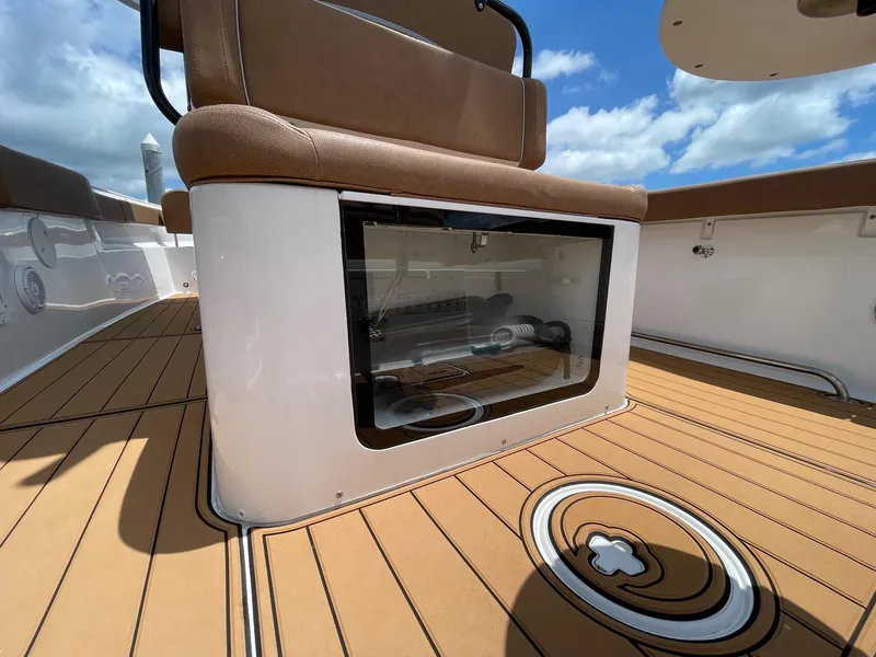 Slide: The Image of 2024 Sea Hunt Ultra 305 SE boat interior with brown seating and storage compartment. - 35