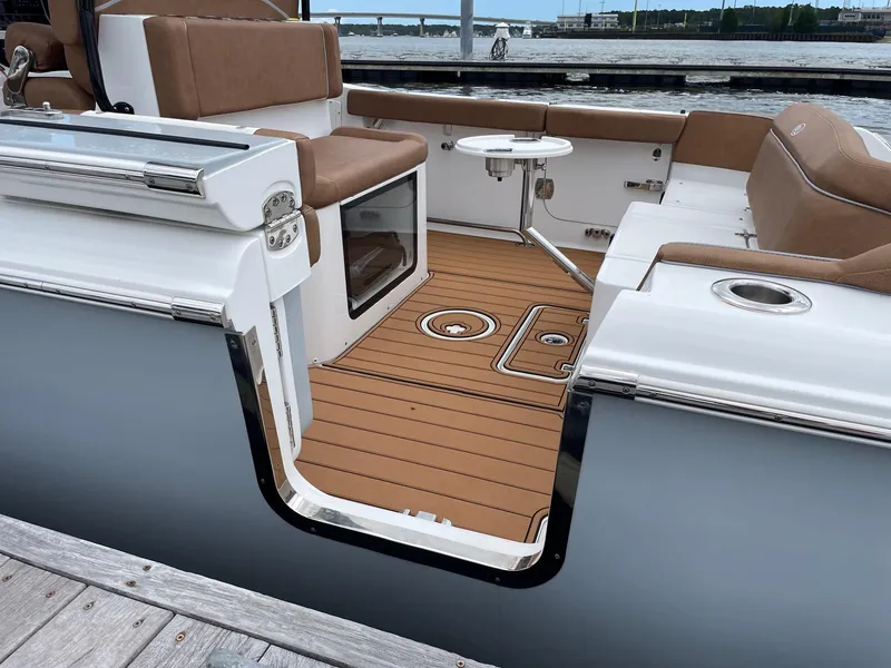Slide: The Image of 2024 Sea Hunt Ultra 305 SE boat interior with brown seating and wooden deck. - 37